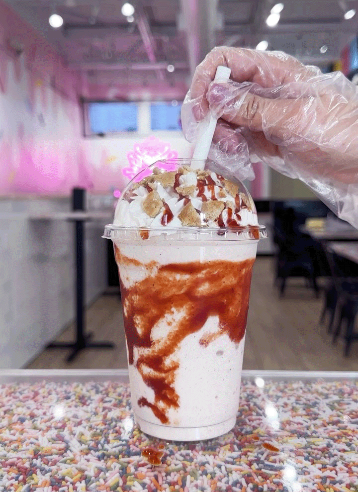 milk shake with caramel drizzle and whipped cream on a table